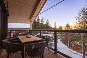 a table and chairs on a balcony with a view at Naturchalets Turracher Höhe by ALPS RESORTS in Turracher Hohe