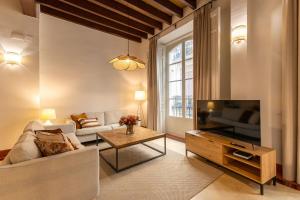 a living room with a couch and a tv at Casa Rental home Campana in Seville