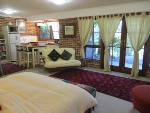 a bedroom with a bed and a table and a kitchen at Warriwul Farmland Rural Retreat BnB, Curramore/Jamberoo in Jamberoo