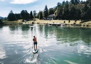 un hombre en una tabla de paddle en el agua en Hotel Samerhof, en Tröpolach