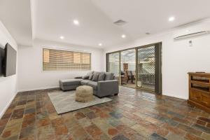 una sala de estar con un sofá y una mesa en White Sands Retreat by Experience Jervis Bay, en Vincentia