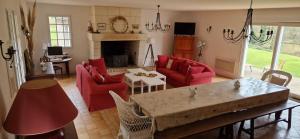 a living room with red furniture and a fireplace at Domaine des Aulnaies - Beauval - Mareuil sur Cher in Mareuil-sur-Cher