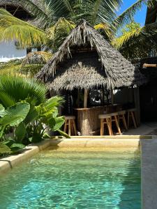 a resort with a swimming pool and a hut at Mlango Paje Villa Boutique in Paje