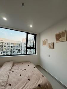 1 cama en un dormitorio con ventana grande en Gao Homestay - Venuestay, en Hue