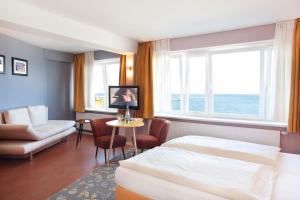 um quarto de hotel com uma cama e uma mesa em Klassik Appartements em Helgoland