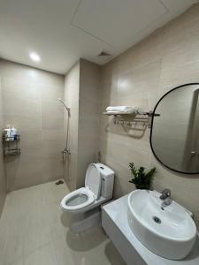 a bathroom with a toilet and a sink and a mirror at Gao Homestay - Venuestay in Hue