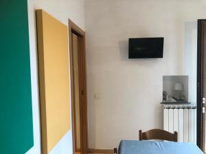 ヴォラストラにあるIl Cortile del Contadinoの壁にテレビとテーブルが備わる客室です。