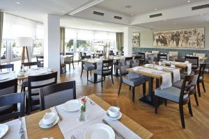 a dining room with tables and chairs in a restaurant at Hotel Erholung in Kellenhusen
