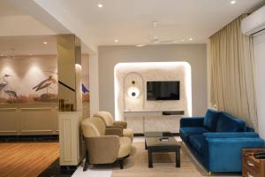 バガにあるRichmonde Ananta Elite Luxurious Villa & Apartments,Goaのリビングルーム(青いソファ、椅子付)