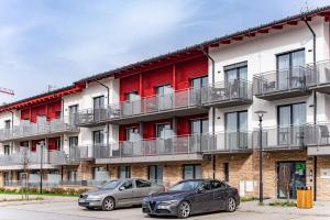 two cars parked in front of a building at Lipno Korzo Residence in Lipno nad Vltavou +17 photos