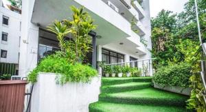 une maison avec une pelouse verte devant elle dans l'établissement The bmk Hotel by Scoovey hospitality, à New Delhi