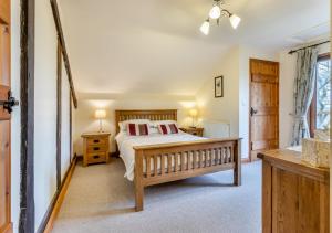 TrefeglwysにあるDerw Lodgeのベッドルーム1室(ベッド1台、テーブル2台、窓付)