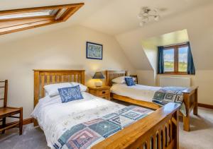 two twin beds in a room with a balcony at 1 Derw Cottages in Trefeglwys