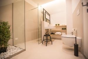 een badkamer met een glazen douche en een toilet bij Albergo Diffuso Dimora Rossi Suite B&B in Turi