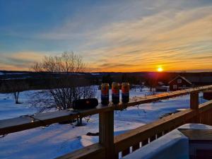 uma fila de três garrafas numa cerca na neve em SHEPHERD'S INN 