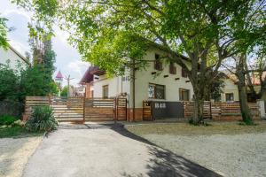 une maison avec une clôture et un arbre dans l'établissement B48 Simplex - egyszinten, kényelmesen, à Törökbálint