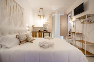 - une chambre blanche avec un grand lit blanc dans l'établissement Dimora Giulia, luxury suite and spa, à Castellana Grotte