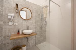 La salle de bains est pourvue d'un lavabo et d'une douche. dans l'établissement Dimora Giulia, luxury suite and spa, à Castellana Grotte