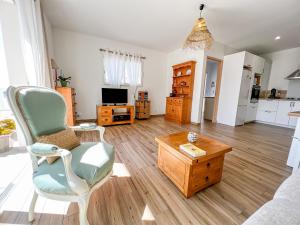 un soggiorno con una sedia e un tavolo di Léna - Maison, Terrasse vue mer, Clim - by TGB a Albitreccia