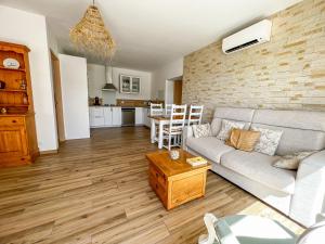 un soggiorno con un divano e un tavolo di Léna - Maison, Terrasse vue mer, Clim - by TGB a Albitreccia Altre 29 foto