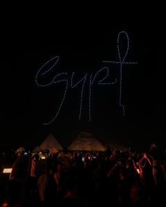 een menigte mensen die voor een kruis staan bij Pyra Hospitality West Pyramids Cairo in Caïro