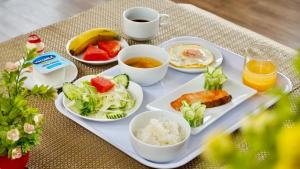 uma bandeja de comida com arroz e fruta e uma chávena de café em Blue Hanoi Hotel em Hanói