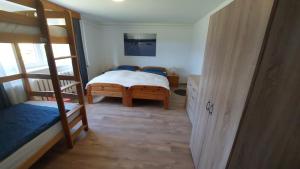 1 dormitorio con 1 cama y 1 litera en Ferienwohnung an der Loipe en Bienenmühle