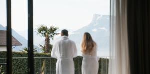 una sposa e uno sposo che guardano fuori da una finestra sulle montagne di Hotel Paradies a Tirolo