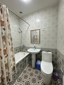 een badkamer met een toilet, een wastafel en een bad bij Faxriddin Guesthouse in Bukhara