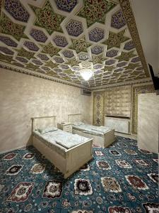 um quarto com duas camas e um tecto com padrões em Faxriddin Guesthouse em Bukhara