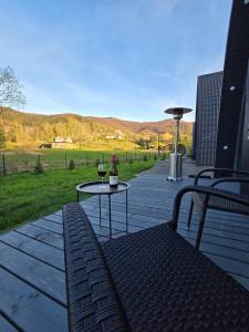 eine Terrasse mit einem Tisch und einem Glas Wein in der Unterkunft Black Dora in Jaremtsche