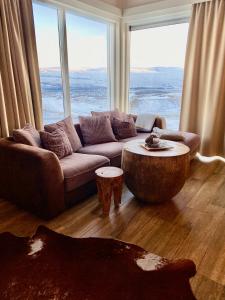 uma sala de estar com um sofá e uma grande janela em Private cottage, elegance & amazing view em Akureyri