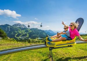 a woman and a child riding on a roller coaster at Hotel Samerhof in Tröpolach
