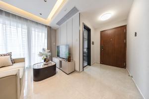 a living room with a tv and a large window at Bailai Qingju - Shenzhen Convention and Exhibition Center in Shenzhen