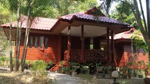 een houten huis met een veranda in het bos bij The Thai Elephant Conservation Center Lampang in Lampang