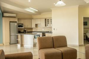 a kitchen with a couch and a chair in a room at Saints View Resort Unit 14 in Uvongo Beach