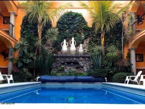 a swimming pool in a house with palm trees at Los Anturios in Cuernavaca