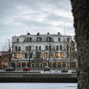 a large white building with cars parked in front of it at Stadshotellet Lidköping in Lidköping