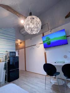 Habitación con sillas y TV en la pared. en Akira&chacha杉並区世田谷direct to shinjuku for 13 min 上北沢4分 近涉谷新宿 en Tokio