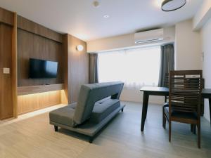 a living room with a chair and a television at Hotel Ichibokaku in Yamanouchi