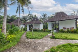 eine Villa mit einem Garten und einem Haus in der Unterkunft Radjes Bungalow Nusa Penida in Nusa Penida