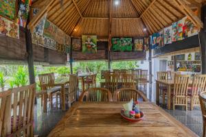 - une salle à manger avec une table et des chaises en bois dans l'établissement Radjes Bungalow Nusa Penida, à Nusa Penida