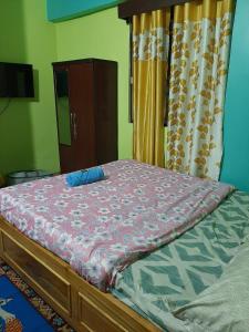 een slaapkamer met een bed met een paars dekbed bij Chewang Homestay in Darjeeling