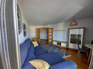 a living room with a blue couch and a television at Marina in Ribeira