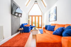 un soggiorno con divano arancione e TV di 2 bed with terrace - Llandaff Lofts by Tŷ SA a Cardiff