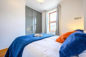 a bedroom with a bed with blue and orange pillows at 2 bed with terrace - Llandaff Lofts by Tŷ SA in Cardiff
