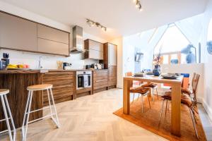 a kitchen with a wooden table and chairs at 2 bed with terrace - Llandaff Lofts by Tŷ SA in Cardiff