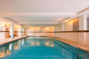 a large swimming pool in a hotel room with a pool at Courtyard Warner Robins in Warner Robins