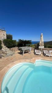 - une piscine avec une table de pique-nique et un banc dans l'établissement Villa Ghjunchitu - Vue mer et Piscine privée proche de l'ile rousse, à Corbara