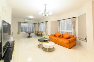 a living room with an orange couch and a table at ็Hill Lake Villa - ฮิลล์เลค วิลล่า in Ban Ton Ngiu